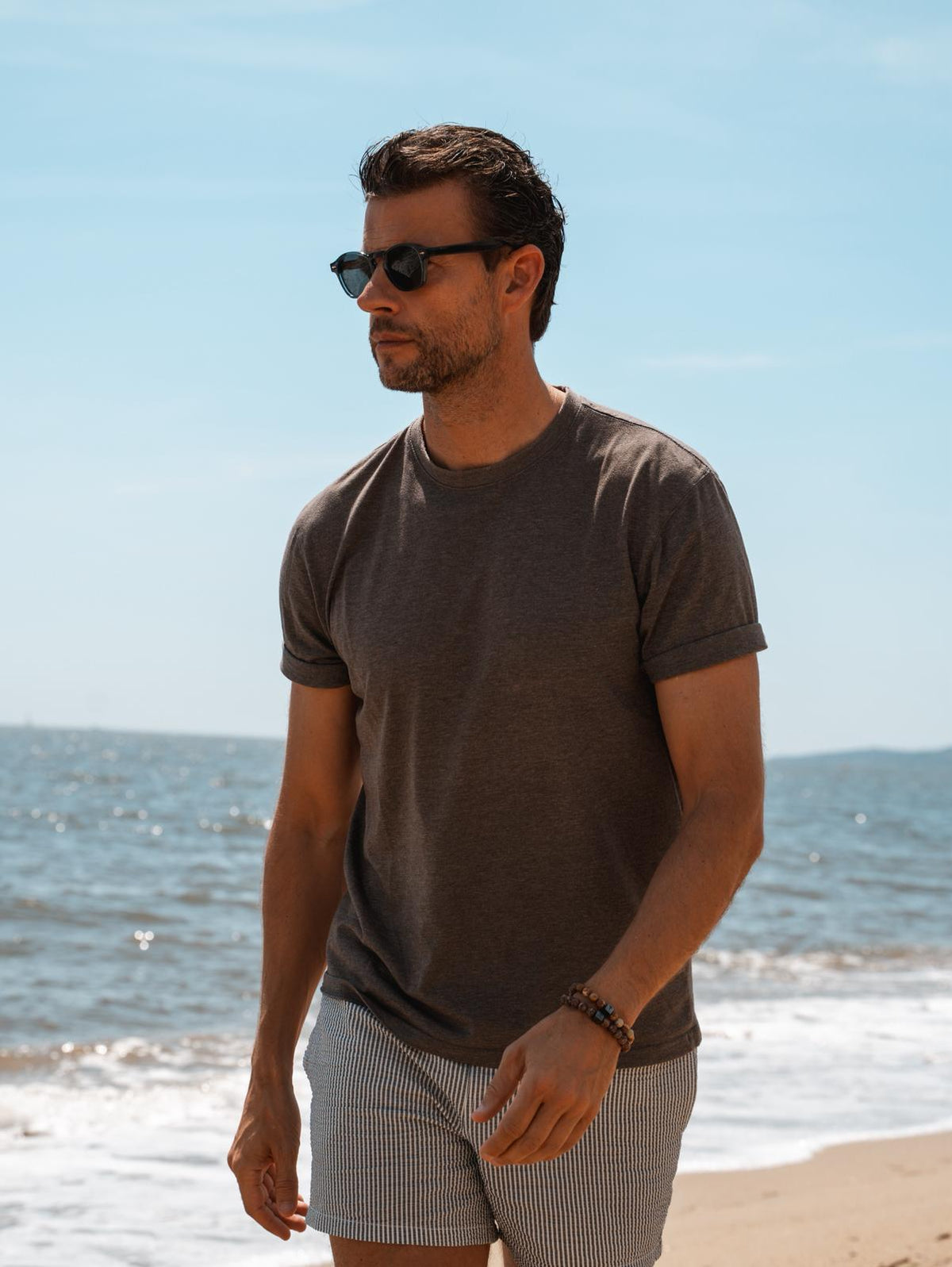 Man aan zee met een natuurstenen armband van Men of Mercury